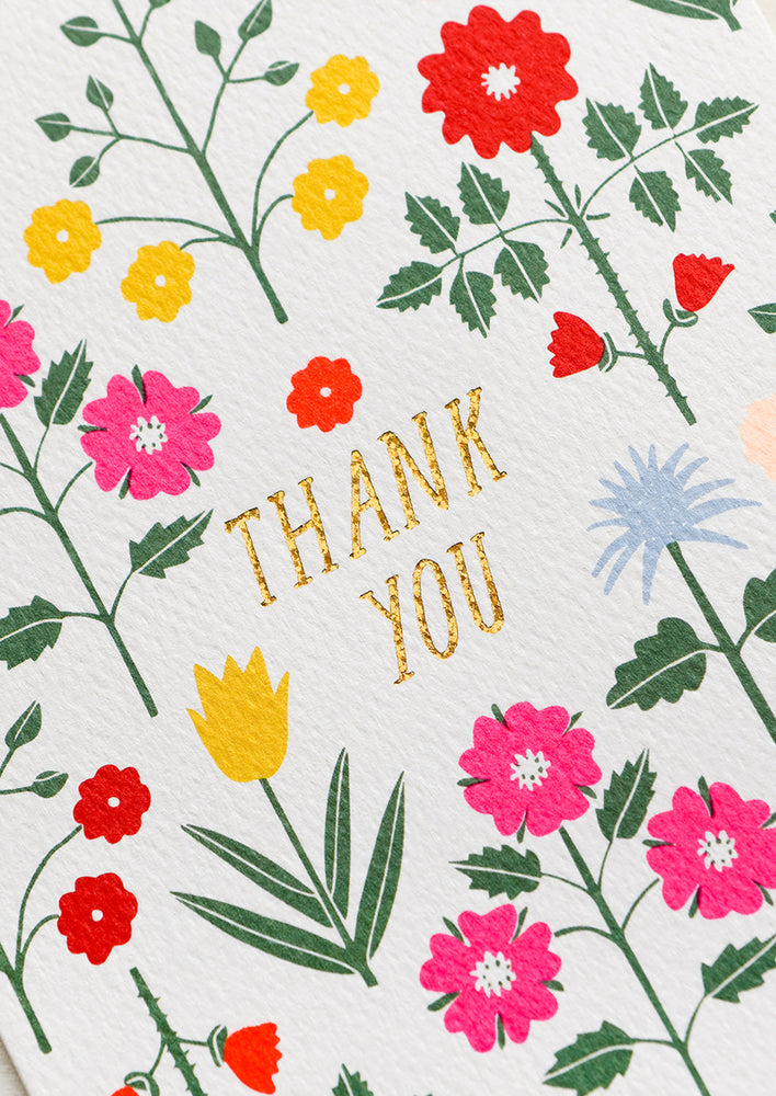 A set of thank you cards with vibrant floral pattern and gold "Thank You" text at center.