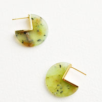 3: Three quarter disc shaped earrings of a yellow-green gemstone speckled with brown flecks with gold hardware and post back.