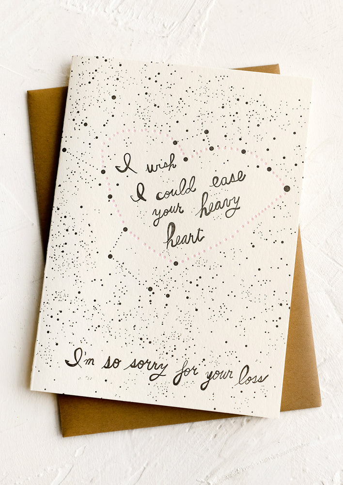 1: A greeting card with constellation print reading "I wish I could ease your heavy heart, I'm so sorry for your loss".