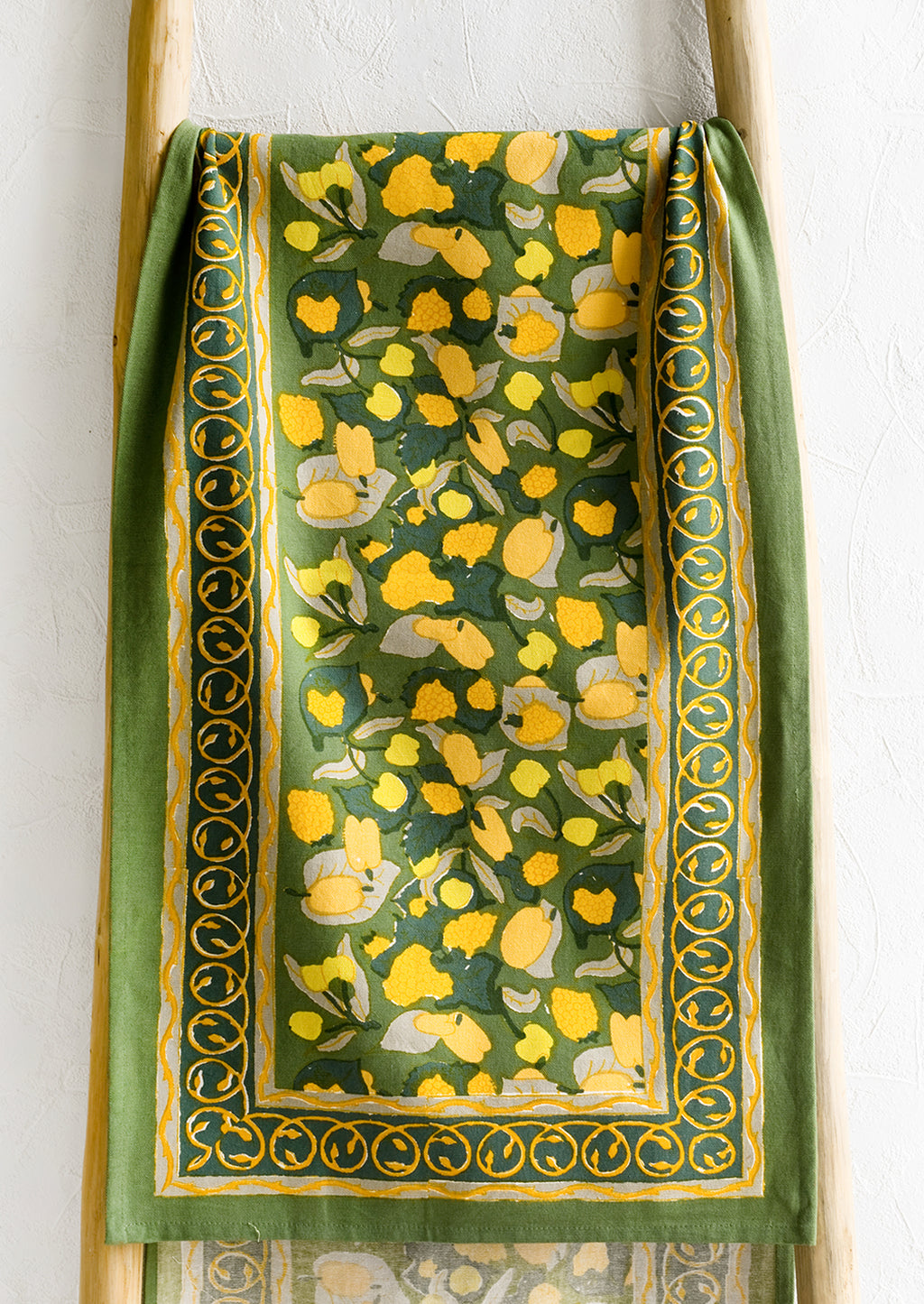 1: A block printed table runner in green and yellow print.