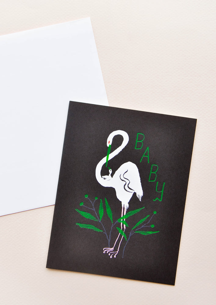 Notecard with white egret on back background and green "Baby" text and decoration, with white envelope.