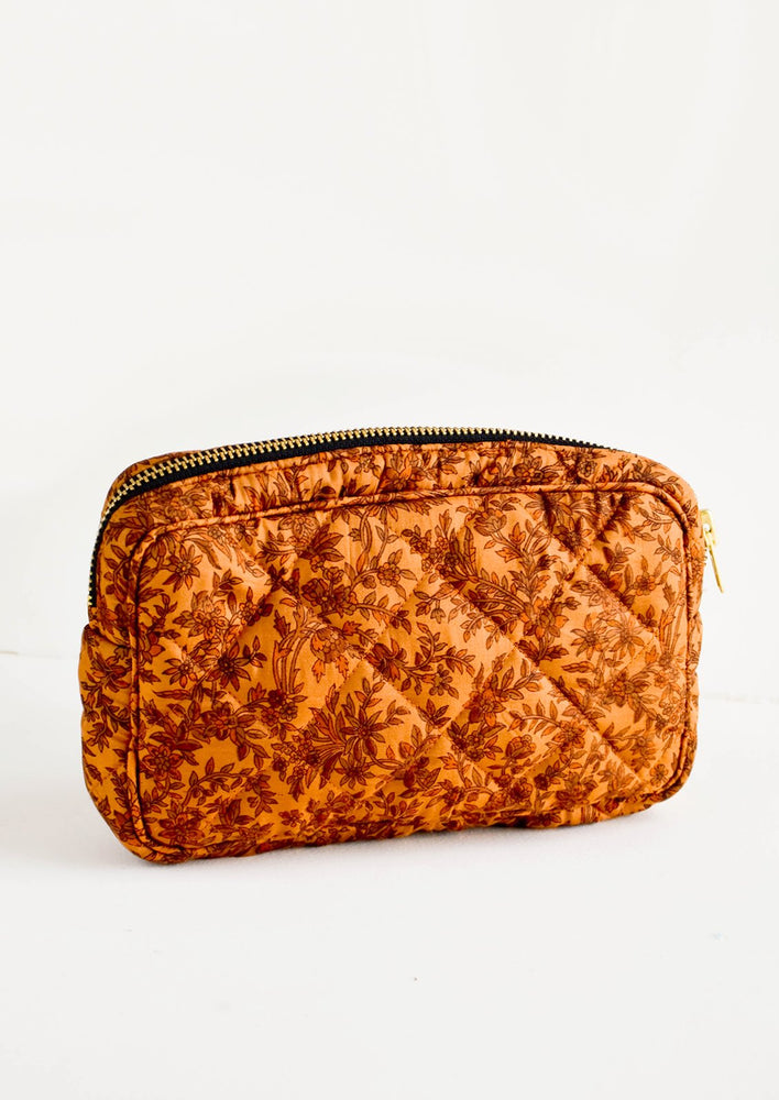 Flat and rectangular makeup travel bag with zip closure in copper floral print