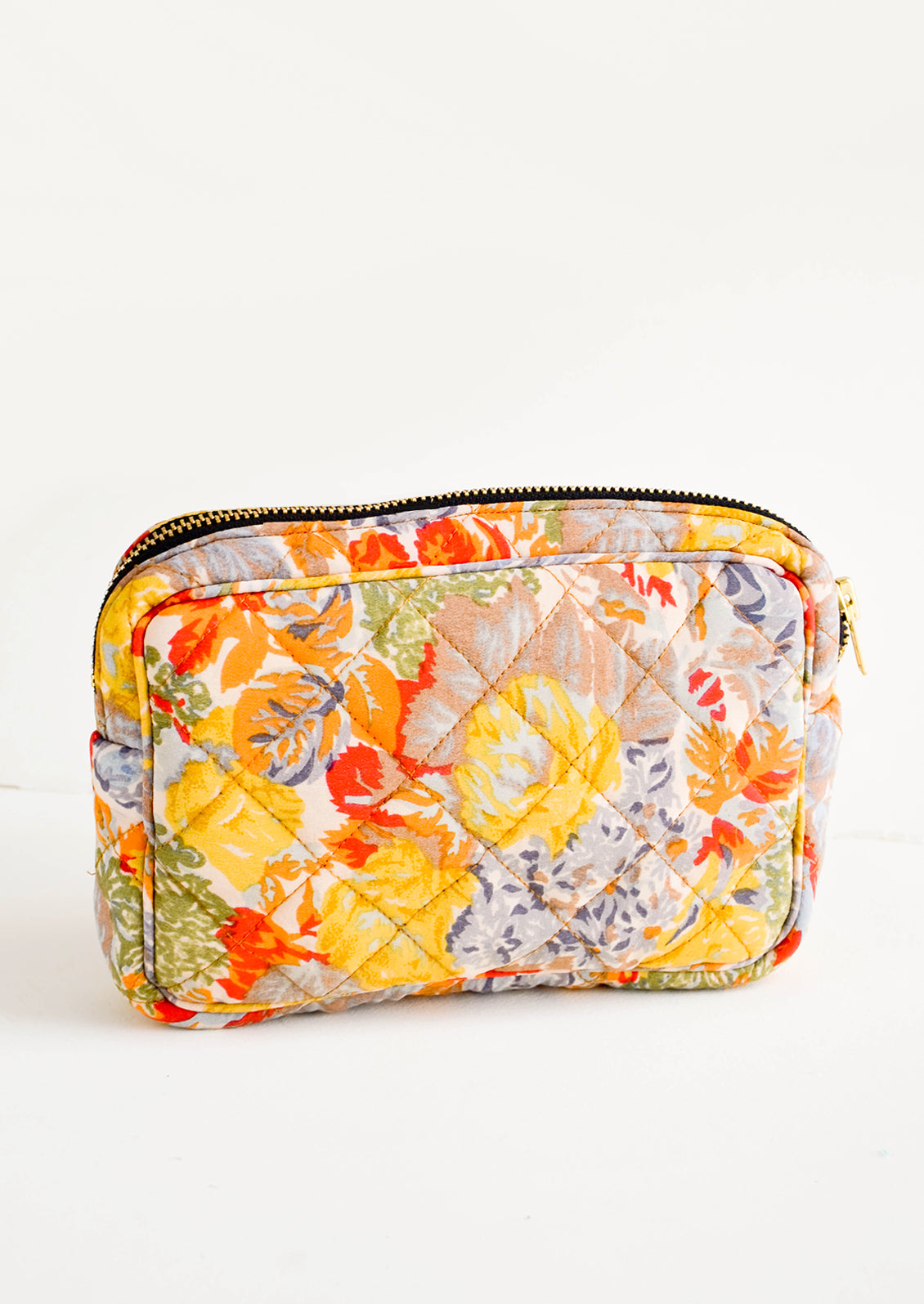 Flat and rectangular makeup travel bag with zip closure in colorful floral print