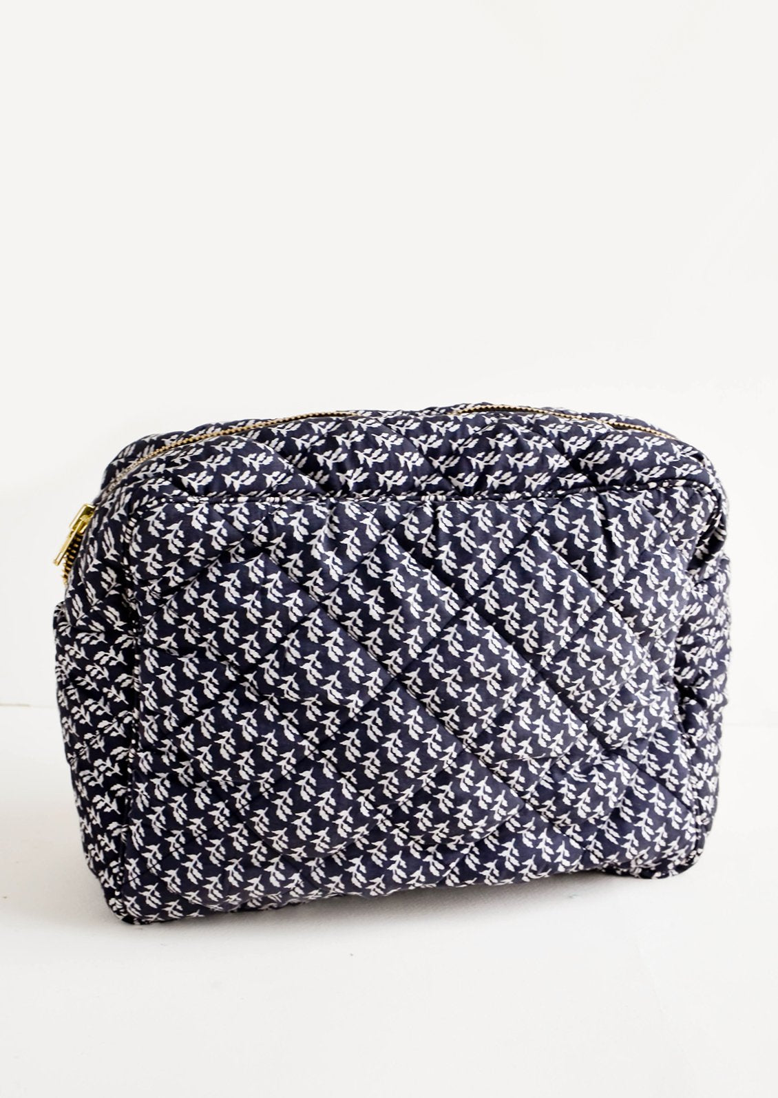 Flat and rectangular makeup travel bag with zip closure in black and white leaf motif