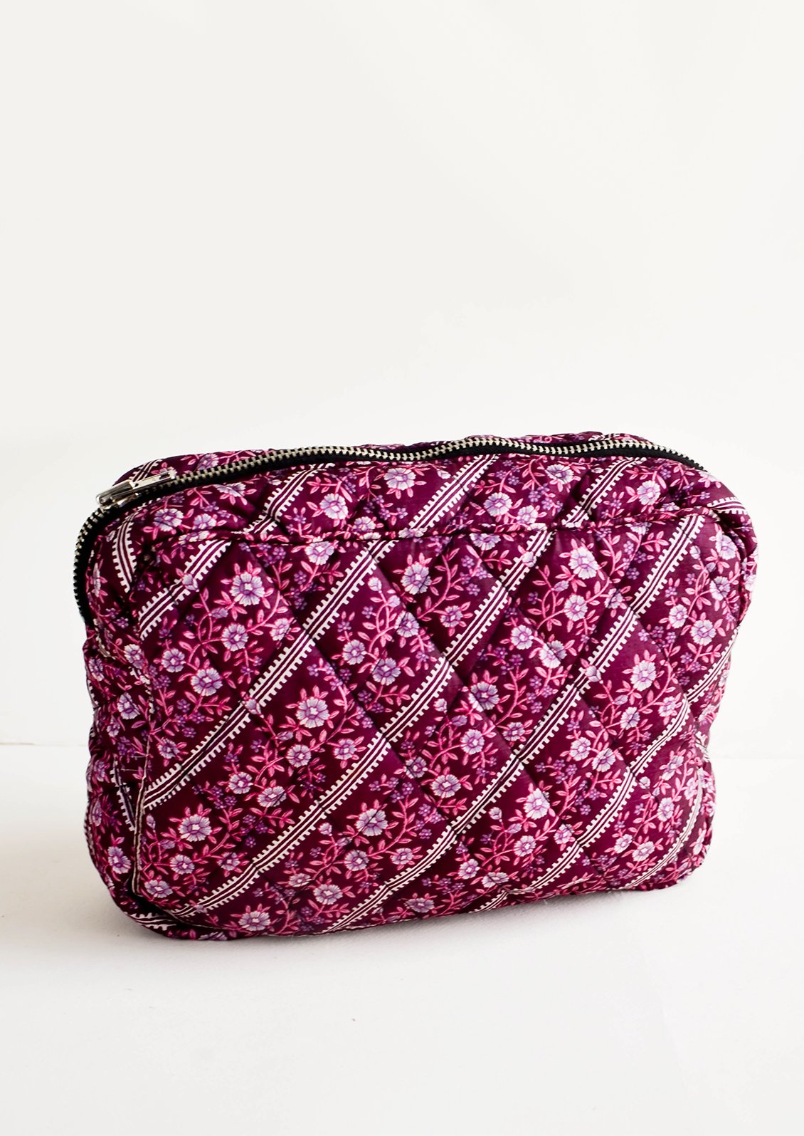 Flat and rectangular makeup travel bag with zip closure in purple floral