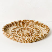 2: A shallow woven pine needle platter with raffia pattern detailing.