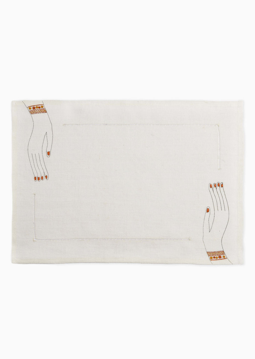 2: A white linen placemat with hemstitch border and embroidered hands at two corners.