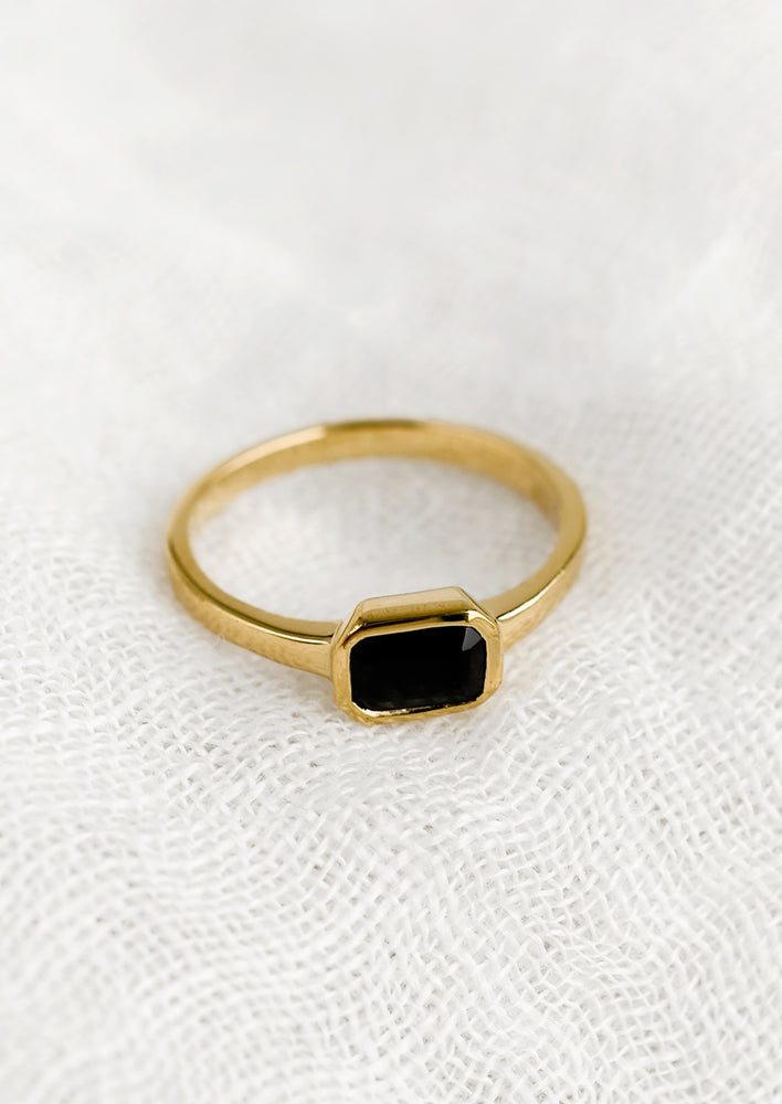 An emerald cut gold ring with onyx stone.