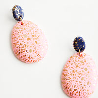 Rose / Navy: Dangling glitter covered earrings, with a peach larger oval dangling from a small dark bead.