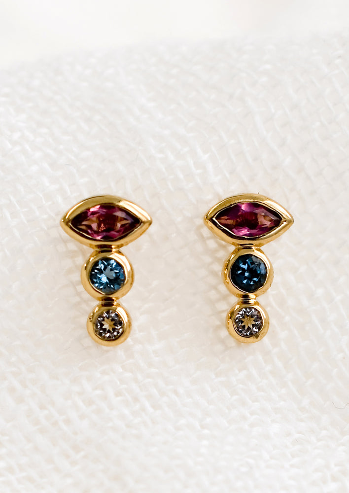 A pair of three-stone stud earrings in pink, blue and clear.