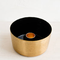 Black: A round brass taper holder with high walls and black enamel lining.