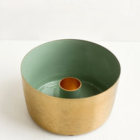 Sage: A round brass taper holder with high walls and green enamel lining.