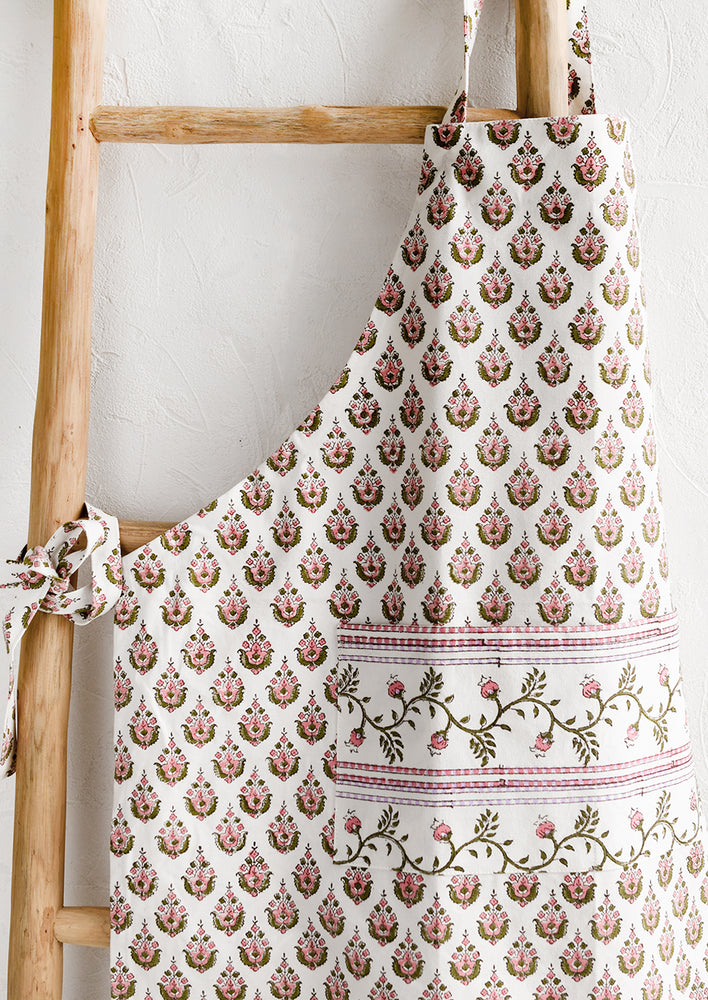 1: A printed apron in pink, green and lavender floral block print.