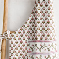 1: A printed apron in pink, green and lavender floral block print.