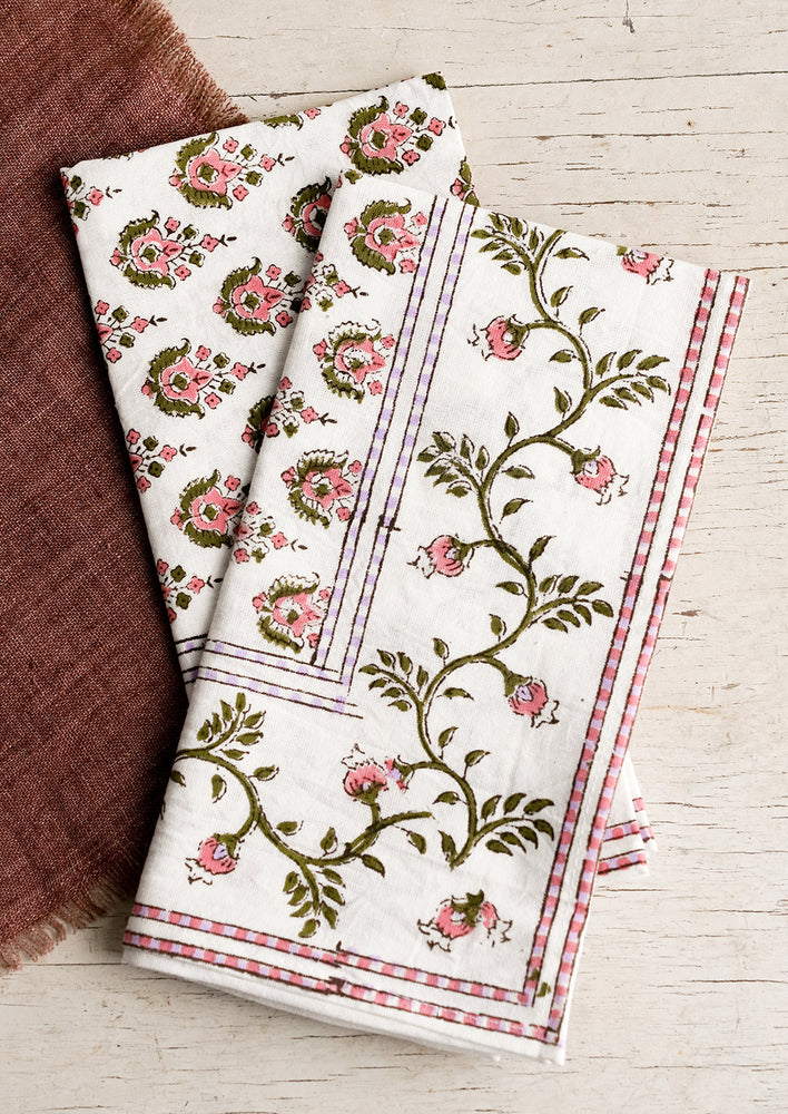 1: A pair of block print napkins in pink and purple floral.