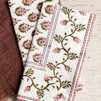 1: A pair of block print napkins in pink and purple floral.