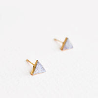 2: Triangular stud earrings of pale gray textured stone in gold setting.