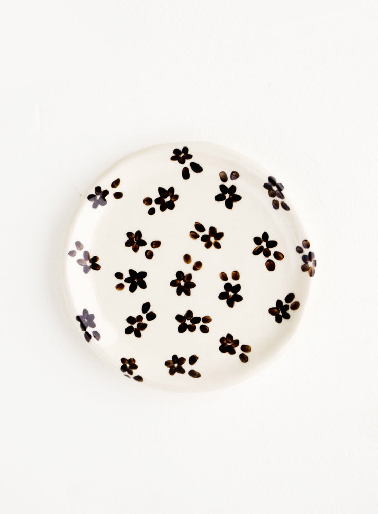 Small, round ceramic dish in white with black floral print