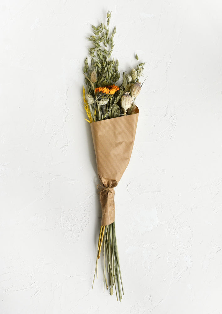 A dried floral bouquet in tones of sage green with hints of yellow.