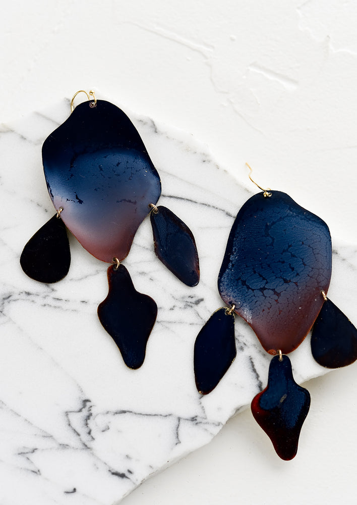 A pair of dark blue enamel earrings in tiered amoeba shape.