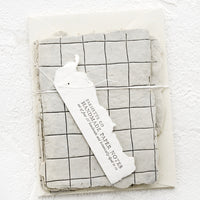 1: Packaged set of cards made from handmade paper with a letterpress printed grid pattern.