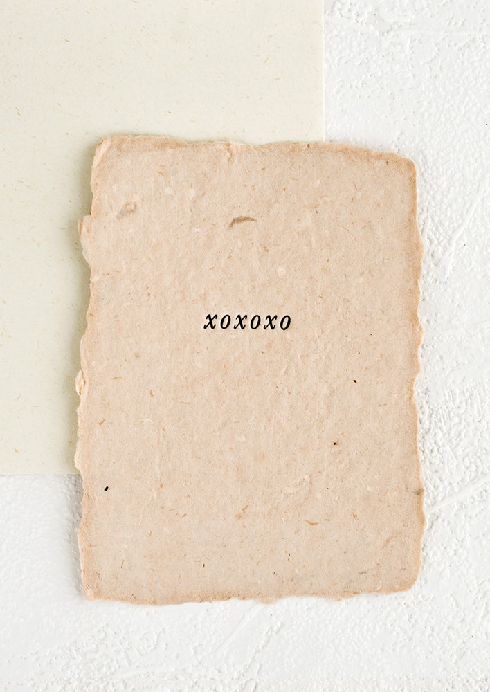 1: A greeting card made from pink handmade paper with "xoxoxo" printed on front.