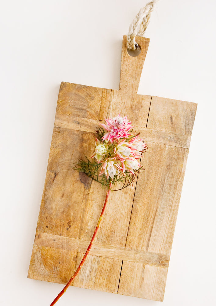 1: Rectangular wooden cutting board with rustic look, displayed with flowers.