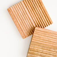 1: Wooden trivets in warm, medium-colored wood with grooved construction and square shape