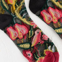 2: A pair of sheer black socks with multicolor creature print.
