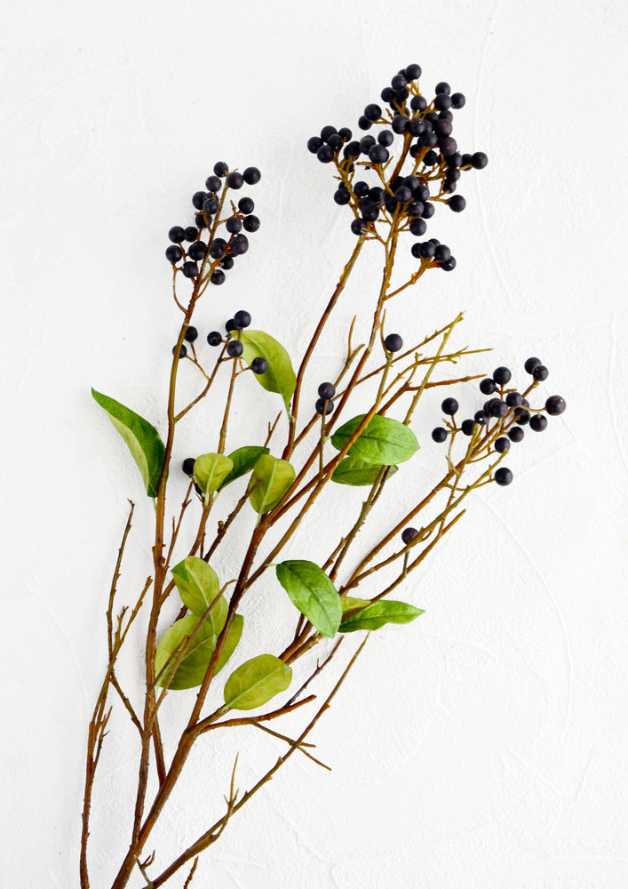 1: Faux branches with green leaves and dark blue privet berries.