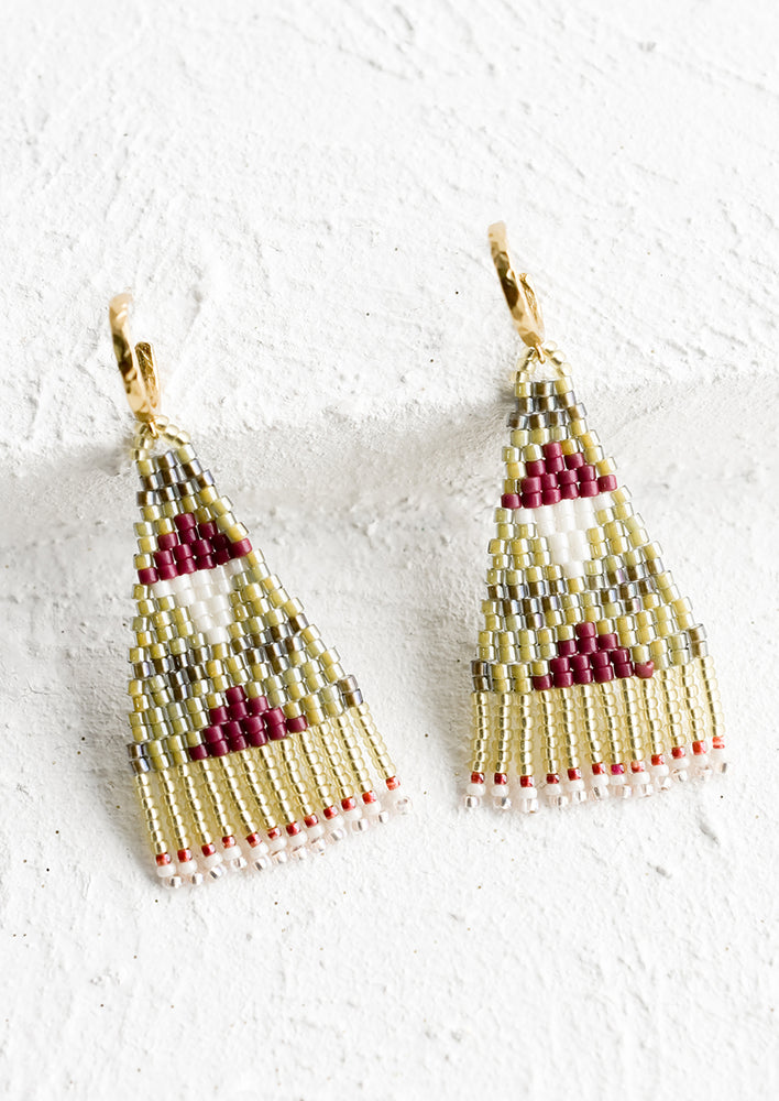 A pair of triangular shaped beaded earrings with geometric pattern in green and dark red.