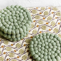 Menthe: A set of round felted wool coasters in mint green.