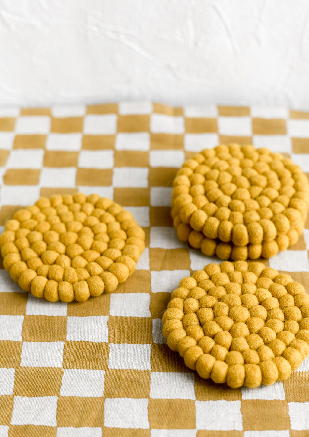 Mustard: A set of round felted wool coasters in mustard.