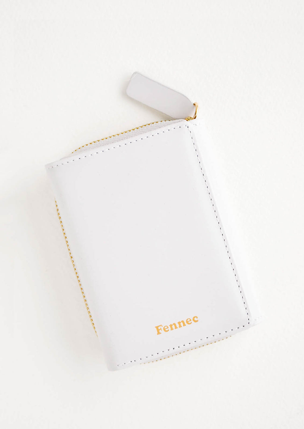 Cloudy: Light grey leather wallet that zips on three sides, in a closed position, with matching tab pull.