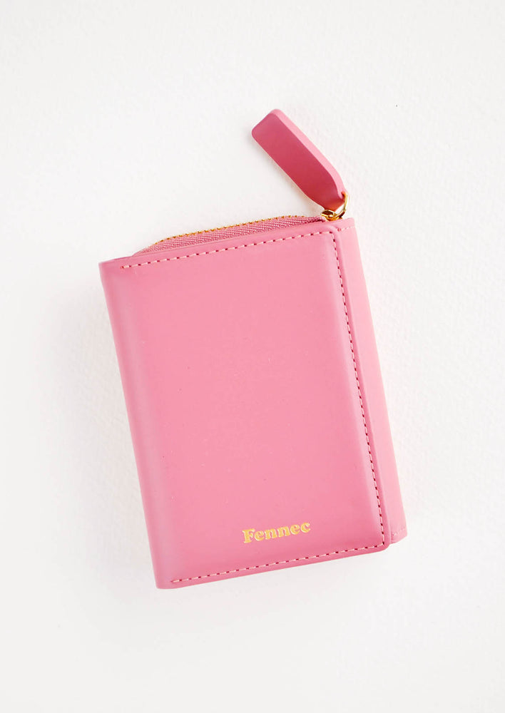 Rose red leather wallet that zips on three sides, in a closed position, with matching tab pull.