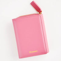 Rose: Rose red leather wallet that zips on three sides, in a closed position, with matching tab pull.