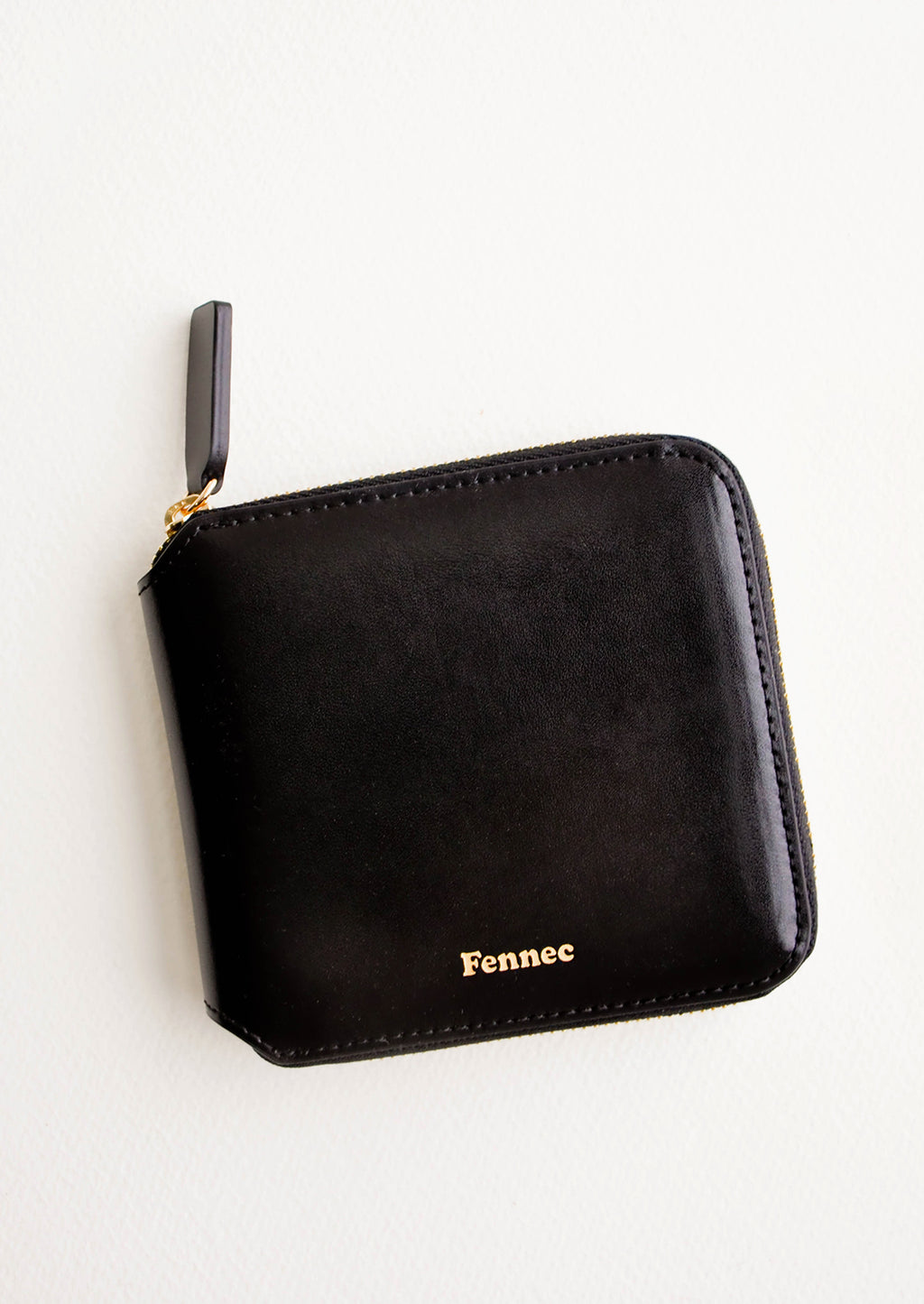 Black: Black leather wallet that zips on three sides, with matching tab pull.