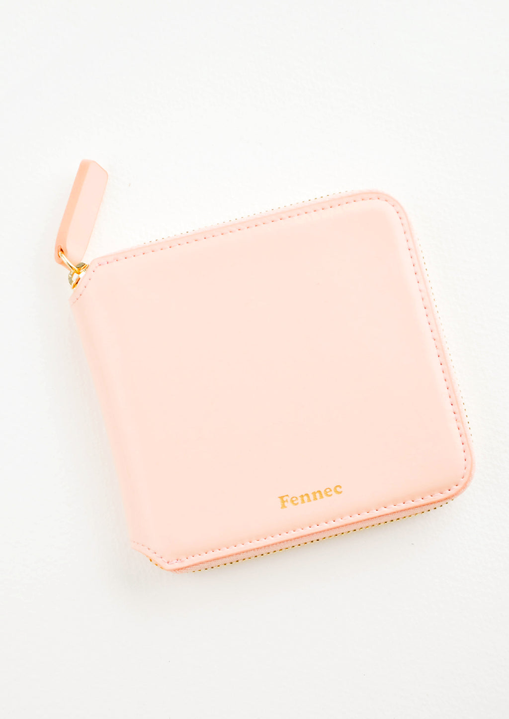 Peach: Light pink leather wallet that zips on three sides, with matching tab pull.