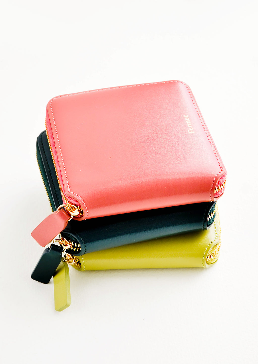 3: Product show showing multiple colors of zip wallets in a stack.