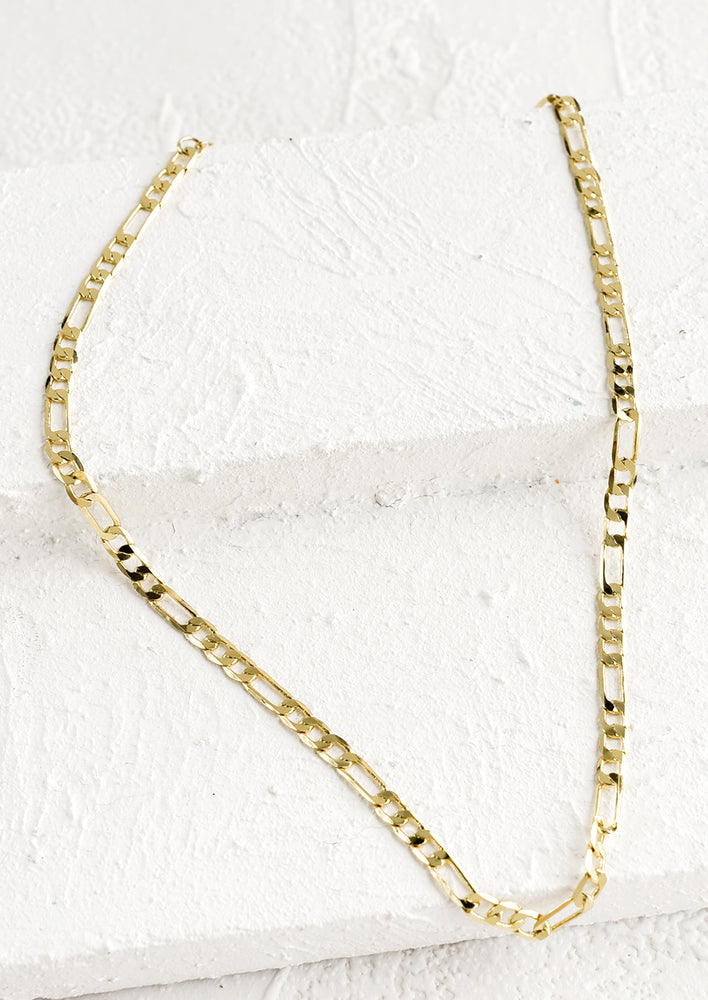 A gold necklace with Figaro-style chainlink.