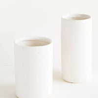 4: Vases made from white, textured concrete-like material in two different sizes, short and tall