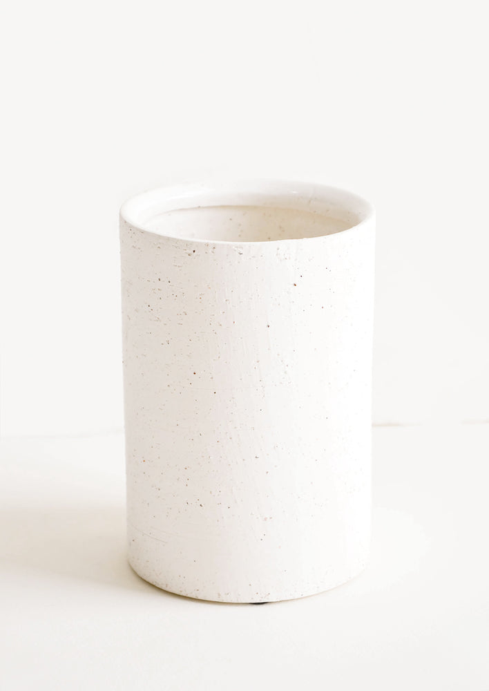 Vase in short and wide silhouette made from textured, concrete-like material in white