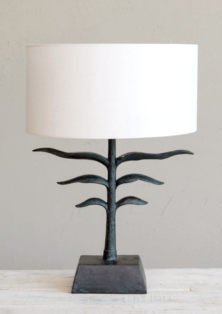 1: A lamp with black leaf base and natural linen shade.