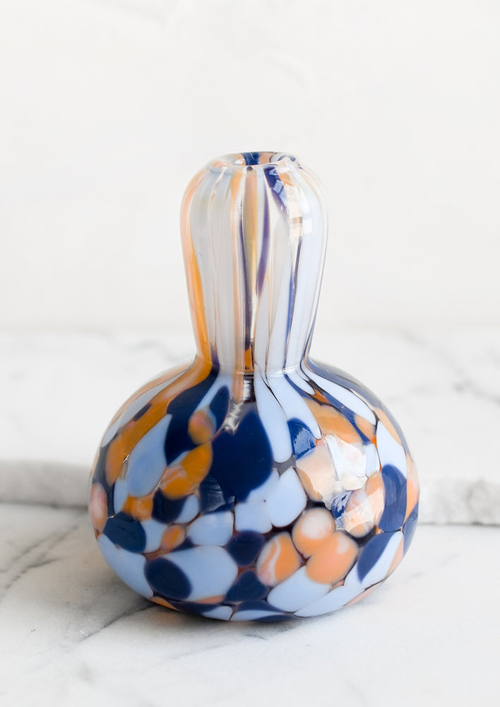 A gourd shaped bud vase in hand blown glass with blue and orange speckle pattern.