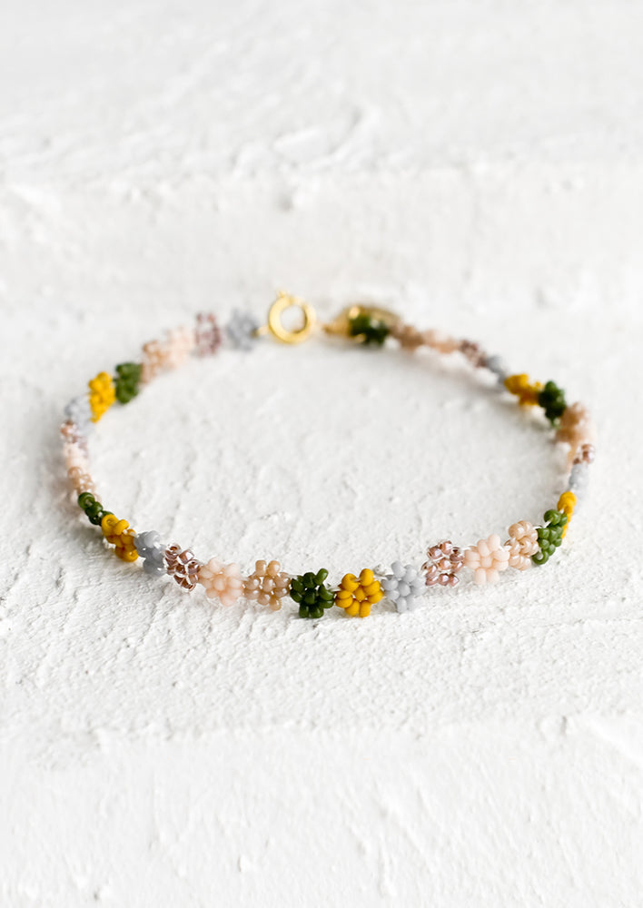Rosado Multi: A beaded bracelet in flower shape in dusty pink, mustard, grey and olive.