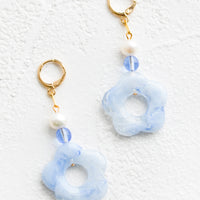 Blue / White: A pair of pearl and blue/white flower beaded dangle earrings strung from a gold huggie hoop.