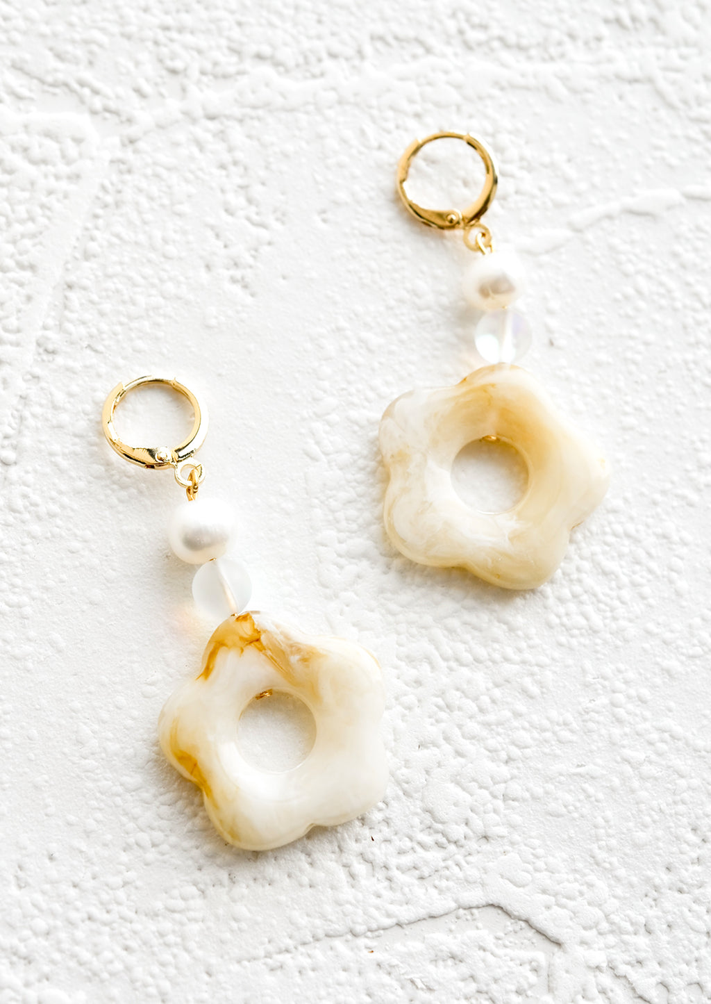 Beige / Clear: A pair of pearl and tan/white flower beaded dangle earrings strung from a gold huggie hoop.