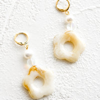 Beige / Clear: A pair of pearl and tan/white flower beaded dangle earrings strung from a gold huggie hoop.
