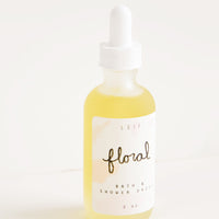 Floral: A small frosted glass dropper bottle with a white lid and label reading "floral" filled with a pale yellow liquid.