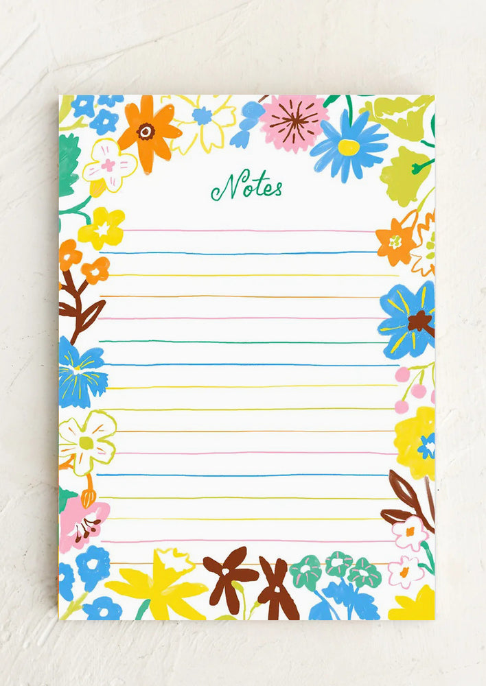 A ruled notepad with colorful floral border.